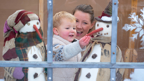 A mother and child enjoy Christmas decorations in Tyntesfield's Orangery